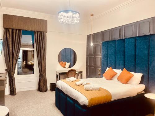 珀斯The Lovat Hotel的一间卧室配有一张大床和蓝色床头板