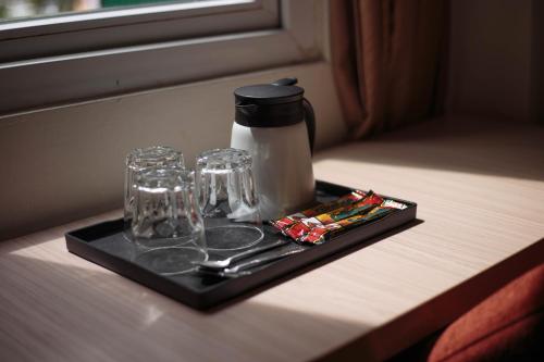 乔治市Sunstone Hotel的玻璃杯托盘和桌子上的咖啡壶