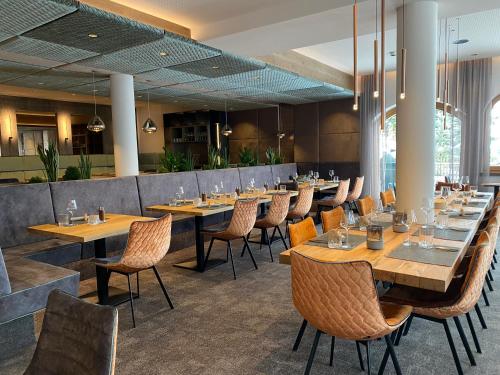 伊施格尔阿尔皮纳酒店的用餐室配有木桌和椅子