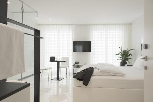 雷根斯多夫Residence Thessoni Home, Hotel & serviced apartments Zürich的白色卧室配有床和书桌