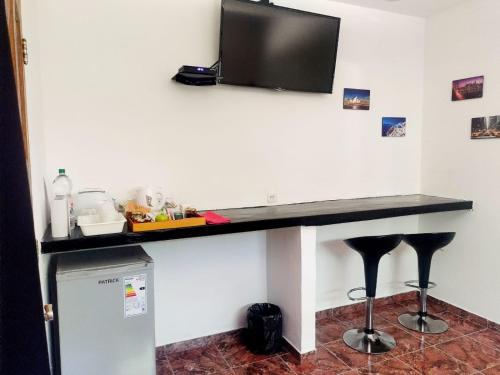埃塞萨Posada Quinta Pata的一张桌子,墙上有一台电视和凳子