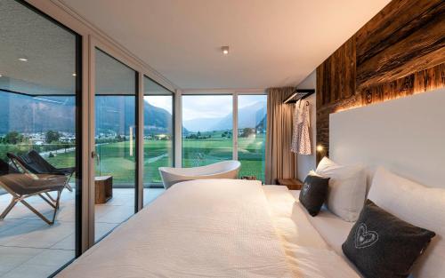 布鲁尼科Bellevue Bruneck - Suites & Lofts的一间卧室设有一张大床和一个大窗户