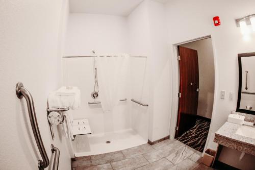 国际瀑布城Cobblestone Hotel & Suites International Falls的带淋浴和盥洗盆的白色浴室