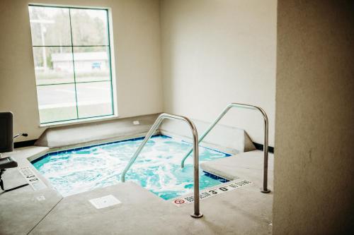 国际瀑布城Cobblestone Hotel & Suites International Falls的带窗户的客房内的热水浴池