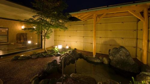 山中湖村富士山の見える全室個室サウナ付旅館 しずく的一座在晚上有池塘的建筑