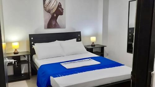 里奥阿查La Marina -Apartamentos frente al mar的一间卧室配有一张带蓝白色毯子的床