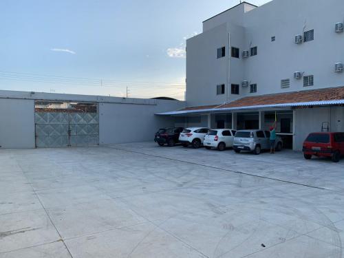 CastanhalHotel Estrela的停车场位于一座有停车车的建筑前面