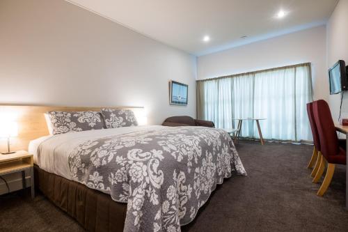 福克斯冰川韦斯赫温汽车旅馆的一间卧室配有一张床、一张桌子和一个窗户。