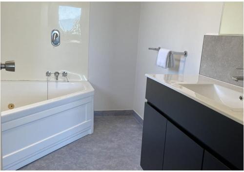 凯库拉蓝色海洋汽车旅馆 的带浴缸、水槽和浴缸的浴室