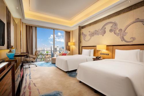 东莞东莞富力万达文华酒店的酒店客房设有两张床和一个阳台。