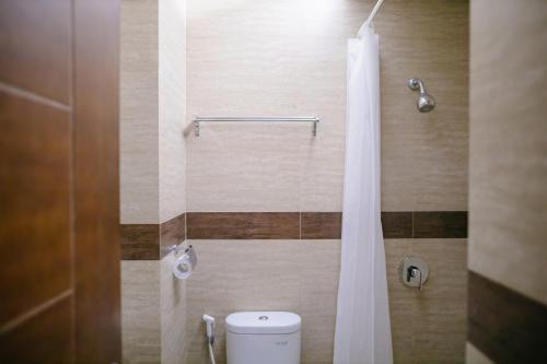 安汶Biz Hotel Ambon的浴室配有带浴帘的卫生间