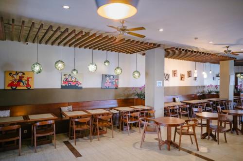 安汶Biz Hotel Ambon的用餐室配有木桌和椅子
