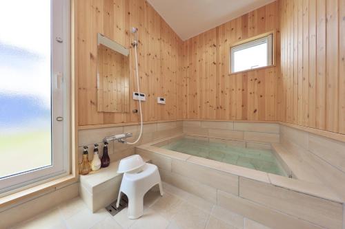 白滨Crystal Besso Uminomachi的大型浴室设有浴缸和淋浴。