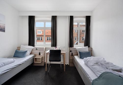 埃斯比约安斯伽酒店的客房设有两张床、一张书桌和两个窗户。