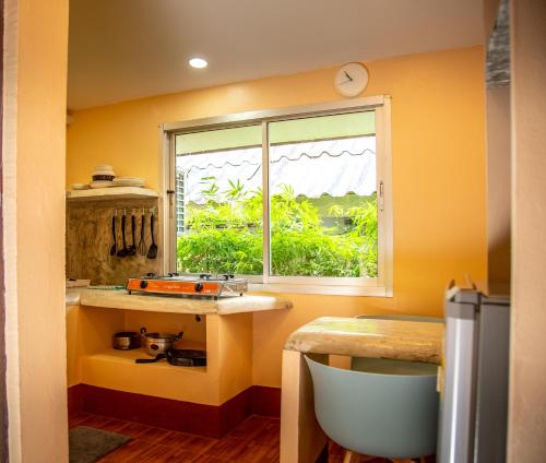 象岛Filou Studio Butterfly Pool Access 29 66的黄色的厨房,带有窗户和桌子