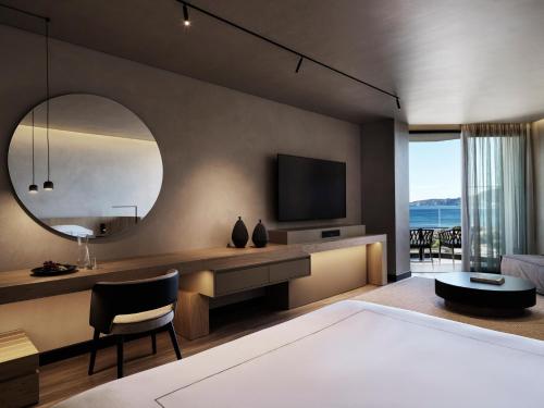 法里拉基Ammades All Suites Beach Hotel - Adults Only的一间带大镜子和电视的卧室
