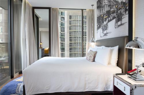 曼谷曼谷无线路英迪格酒店的卧室设有白色的床和大窗户