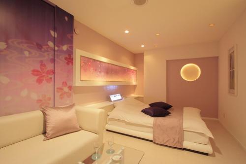 旭川旭川ホテルリップローズ-大人専用的一间带床和沙发的小卧室