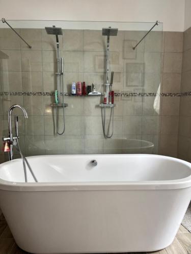 Saint-Geniès-de-FonteditLe Marronnier的浴室设有带淋浴的白色浴缸。