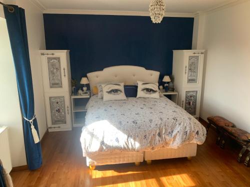 希农La Douce France Trianon的一间卧室配有一张蓝色墙壁的床