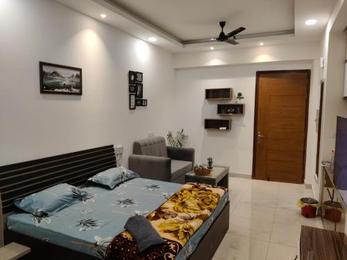 诺伊达The Forest Stays-Luxury Studio Apartment In Noida的一间卧室,卧室内配有一张床和一把椅子