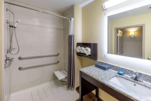 杜兰特La Quinta Inn & Suites by Wyndham Durant的带浴缸、水槽和镜子的浴室