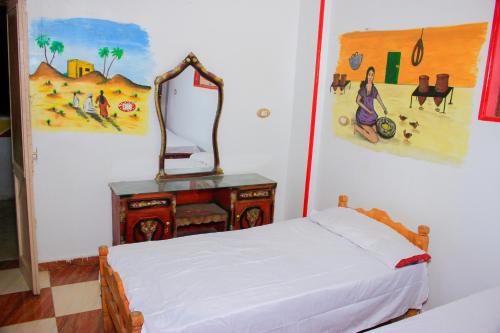 阿斯旺Hamo Guest House的一间卧室配有一张床和一张桌子上的镜子