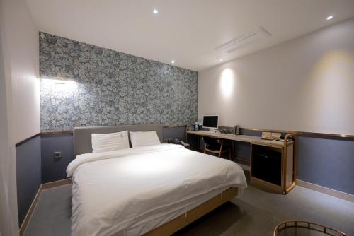 釜山西面 - 北昌杭德酒店的一间卧室配有一张床和一张书桌