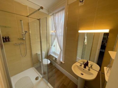 惠特比The Captain's Lodge accommodation的带淋浴、盥洗盆和卫生间的浴室