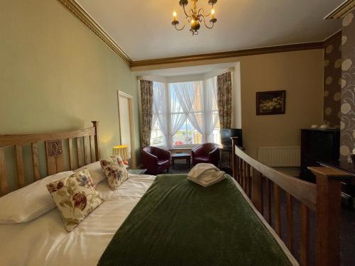惠特比The Captain's Lodge accommodation的一间卧室配有一张床和一个吊灯