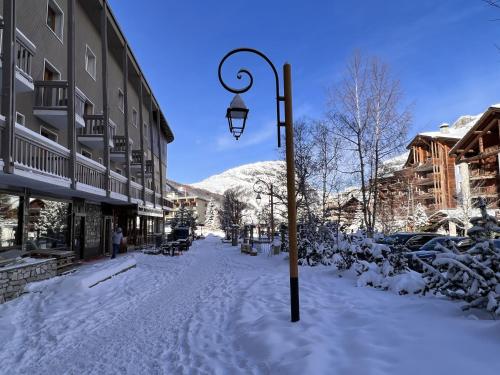 瓦勒迪泽尔Everest Hotel的一条雪覆盖着的街道,一条轻 ⁇ 