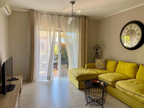 圣米格尔德阿沃纳Juangy’s Apartments in Las Adelfas Golf del Sur的客厅配有黄色沙发和时钟