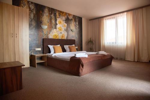 普罗夫迪夫Flamingo Plovdiv的一间卧室设有一张床和鲜花墙