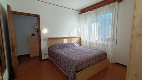 多马索Apartment with garden, lake view and parking - Larihome A15的一间卧室设有一张床和一个窗口