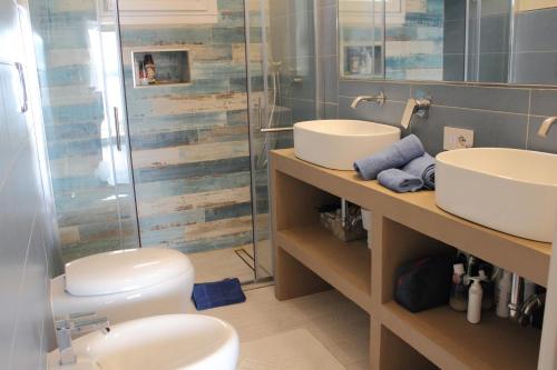 皮图朗格Case al mare di Cala Saccaia的一间带两个盥洗盆、淋浴和卫生间的浴室