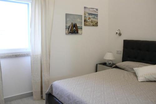皮图朗格Case al mare di Cala Saccaia的一间卧室设有一张床和一个窗口