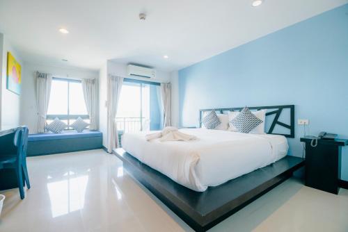 甲米镇睡鲸酒店的卧室配有白色大床和蓝色的墙壁