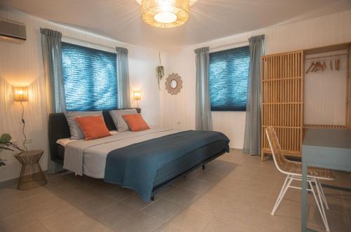 奥拉涅斯塔德NEW ! Cozy Casa的一间卧室配有一张带蓝色床单和橙色枕头的床。