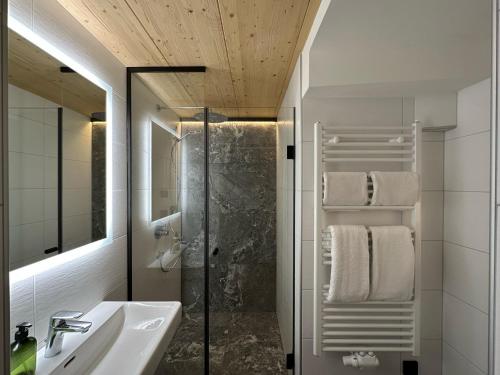 维尔德科格尔山麓布兰贝格Dorferwirt的带淋浴、盥洗盆和镜子的浴室