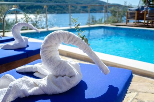 尼亚卢卡Villa Paradise的游泳池畔的桌子上摆放着两条白色毛巾