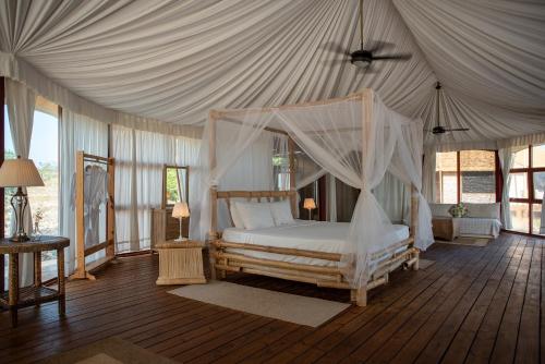 佩德纳莱斯Eco Del Mar的一间帐篷内带天蓬床的卧室