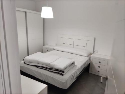马尔皮卡Casa Consuelo Malpica的白色卧室配有床和镜子