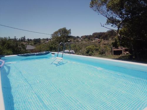 塞拉纳镇Horneritos - Cabaña en Villa Serrana的蓝色的游泳池,里面摆放着椅子