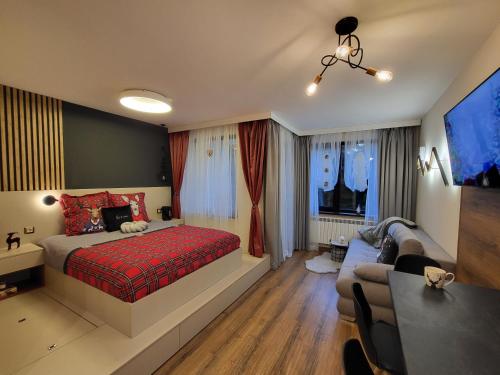 波罗维茨Pinewood ANG luxurious apartment A43, Borovets Gardens的一间卧室配有一张床、一张桌子和一张沙发