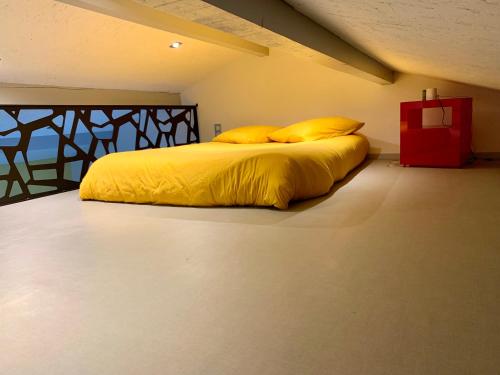 MontcornetStudio à la campagne的一张带黄色床单和枕头的床