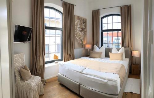 马尔肖Loft mit Seeblick的一间卧室设有一张大床和两个窗户。