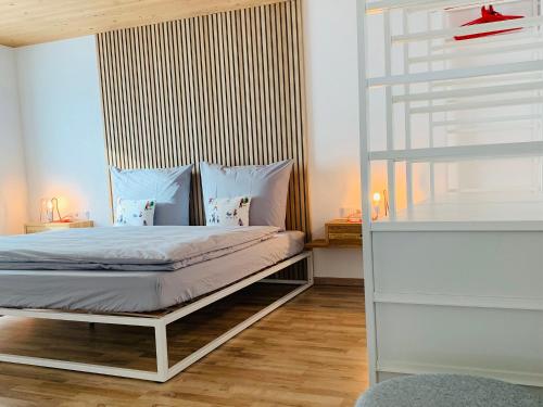 米特尔贝格Dorf(er)leben Ferienwohnung im Kleinwalsertal的一间卧室配有一张床,铺有木地板