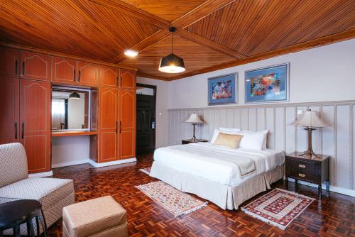 内罗毕Cozy Stead的卧室设有白色的床和木制天花板。
