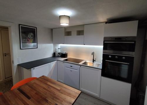 EspergærdeLouisiana Rent的厨房配有白色橱柜、水槽和桌子