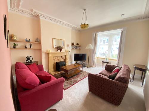 DalrySt John's Flat Spacious Accomodation的客厅设有2张红色的沙发和壁炉